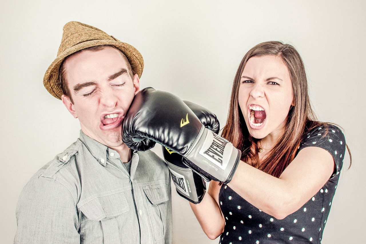 HR process vs culture. Man and a woman fun fighting, woman wearing boxing gloves.