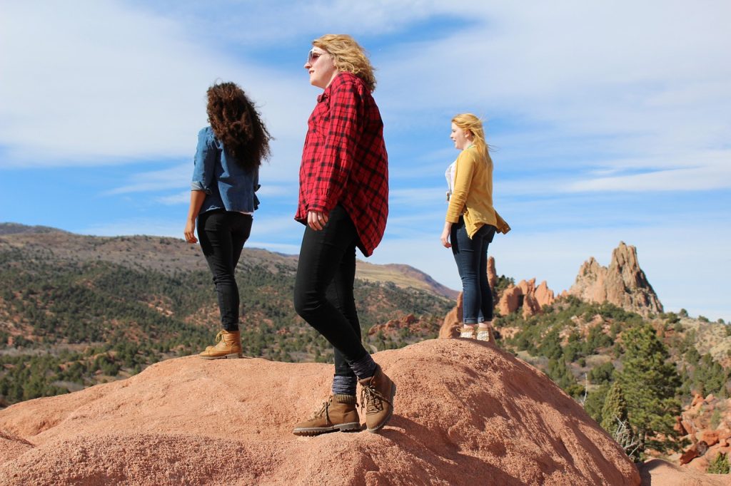 Three young people on a rock overlooking scenery