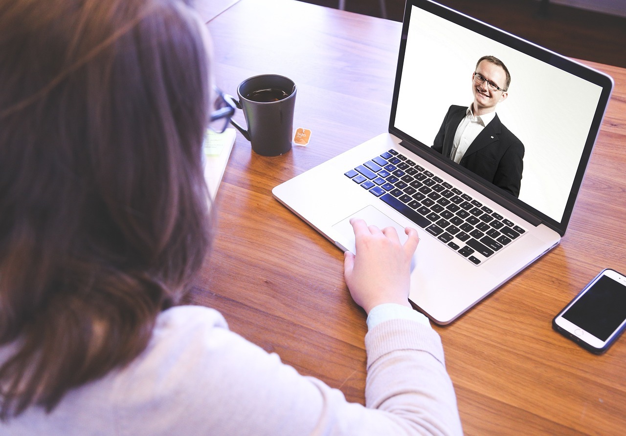Business lady interviewing man via conference call